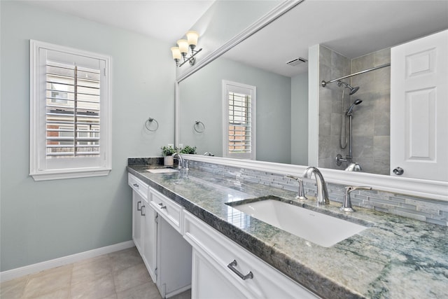 bathroom featuring tile patterned floors, vanity, and backsplash