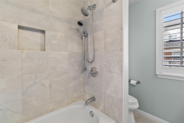 bathroom featuring tile patterned floors, toilet, and tiled shower / bath