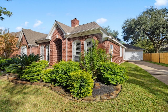 view of front facade featuring an outbuilding, a front yard, and a garage