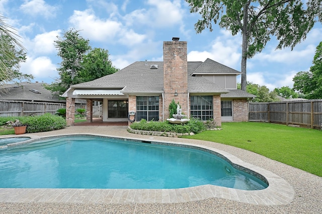 view of swimming pool with a lawn and an in ground hot tub