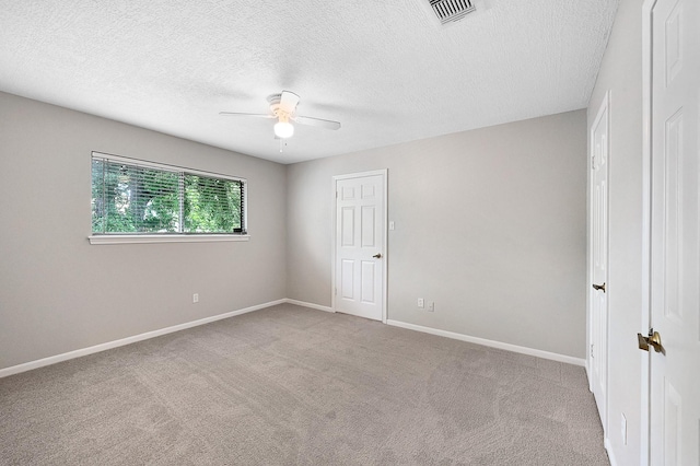 unfurnished room featuring a textured ceiling, light colored carpet, and ceiling fan