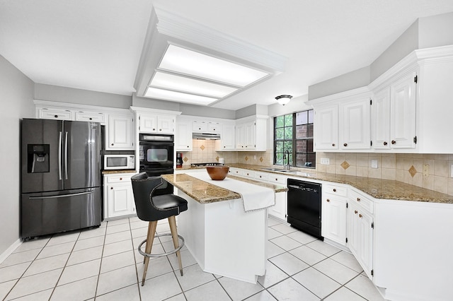 kitchen with dark stone countertops, white cabinetry, a center island, and stainless steel appliances