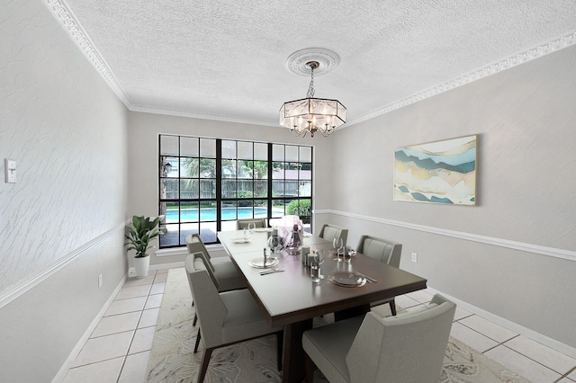 tiled dining room featuring ornamental molding, a textured ceiling, and an inviting chandelier