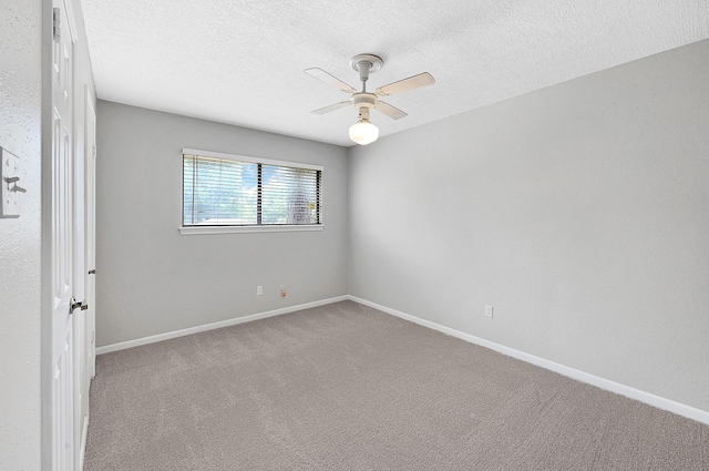 carpeted spare room with ceiling fan and a textured ceiling