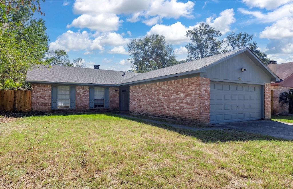 single story home featuring a garage and a front lawn