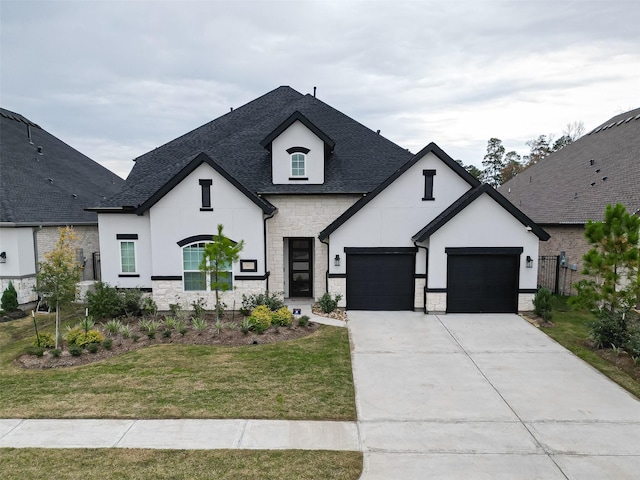 french country home featuring a garage and a front lawn