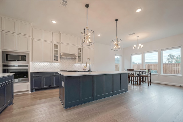 28212 Cedar Peak Dr, Spring, TX 77386 - kitchen with appliances with stainless steel finishes, a chandelier, light countertops, light wood-type flooring, and recessed lighting