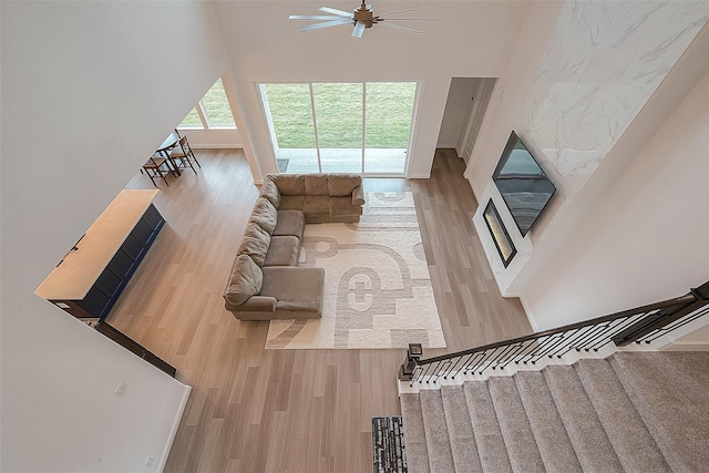 28212 Cedar Peak Dr, Spring, TX 77386 - living area with wood finished floors, a ceiling fan, stairs, and a towering ceiling