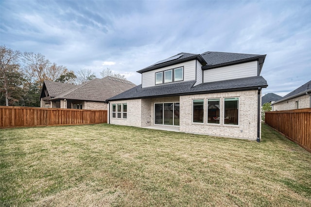 28212 Cedar Peak Dr, Spring, TX 77386 - back of property with brick siding, a fenced backyard, roof mounted solar panels, and a shingled roof