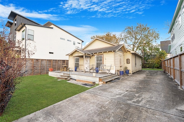 back of house featuring a lawn and a wooden deck