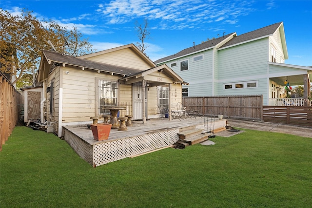 rear view of property featuring a wooden deck and a yard