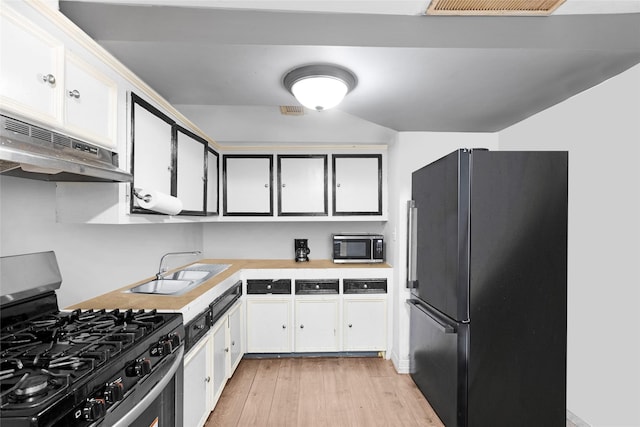 kitchen with white cabinetry, sink, stainless steel appliances, and light wood-type flooring