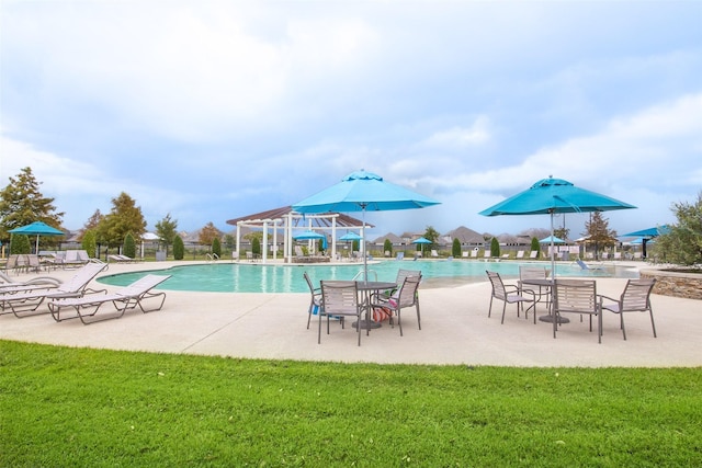 view of pool with a yard and a patio