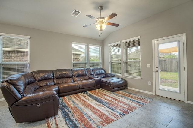 tiled living room with a wealth of natural light, ceiling fan, and lofted ceiling