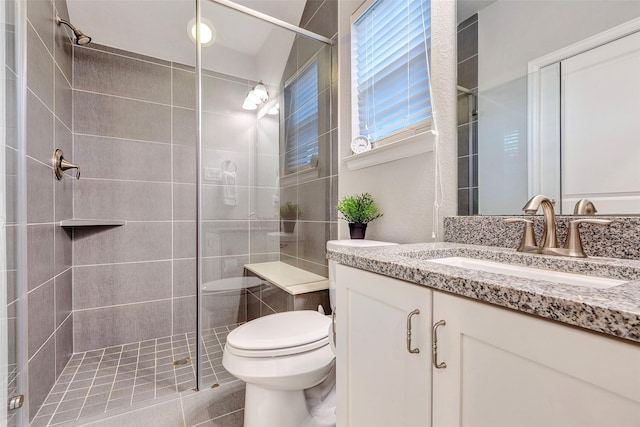 bathroom with tile patterned floors, vanity, toilet, and a shower with door