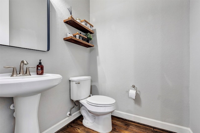 bathroom with toilet and hardwood / wood-style flooring