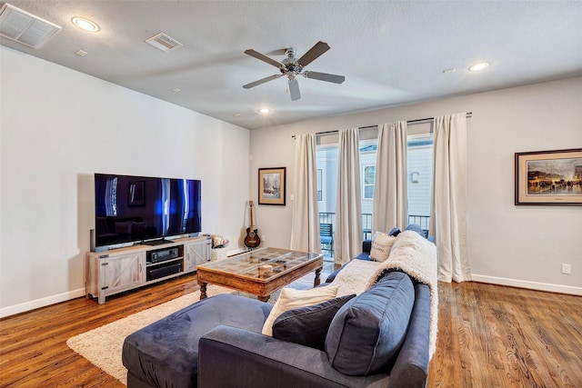 living room with hardwood / wood-style floors, a textured ceiling, and ceiling fan