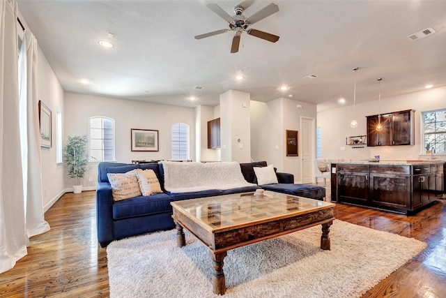 living room featuring ceiling fan, dark wood-type flooring, and sink