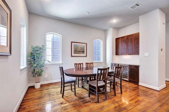 dining area featuring hardwood / wood-style floors and beverage cooler