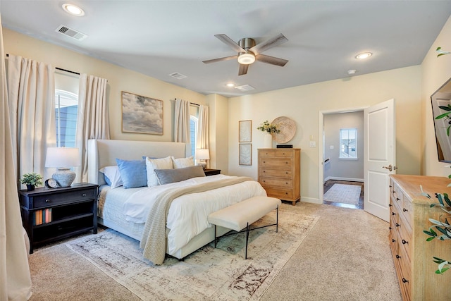 bedroom featuring multiple windows, ceiling fan, and light colored carpet