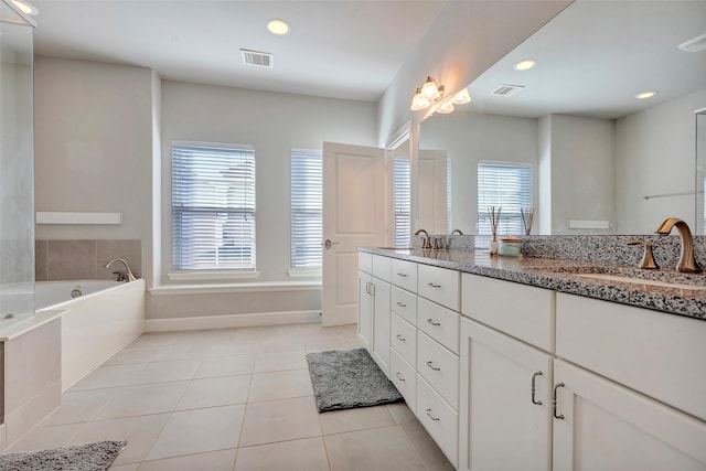 bathroom featuring vanity, tile patterned floors, and a tub