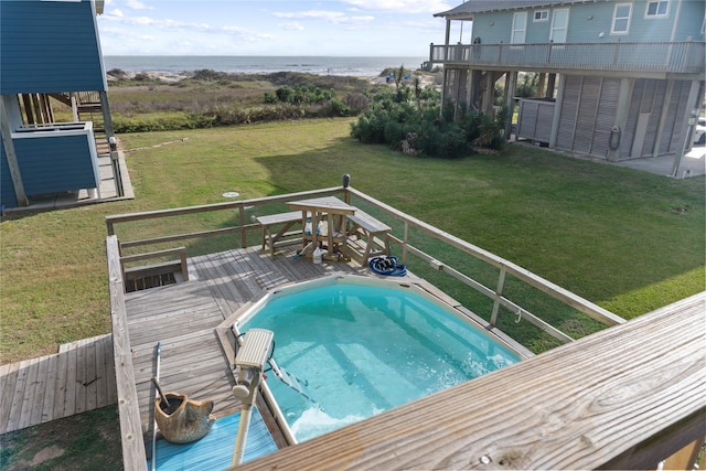 view of swimming pool with a lawn and a deck with water view