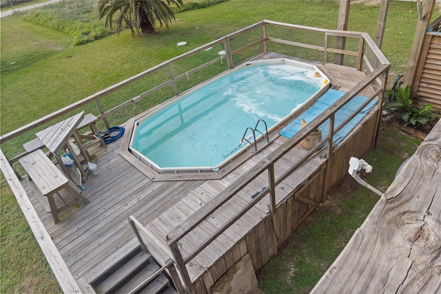 view of pool featuring a lawn and a wooden deck