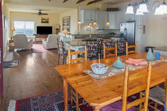 dining room featuring ceiling fan with notable chandelier, dark wood-type flooring, and sink