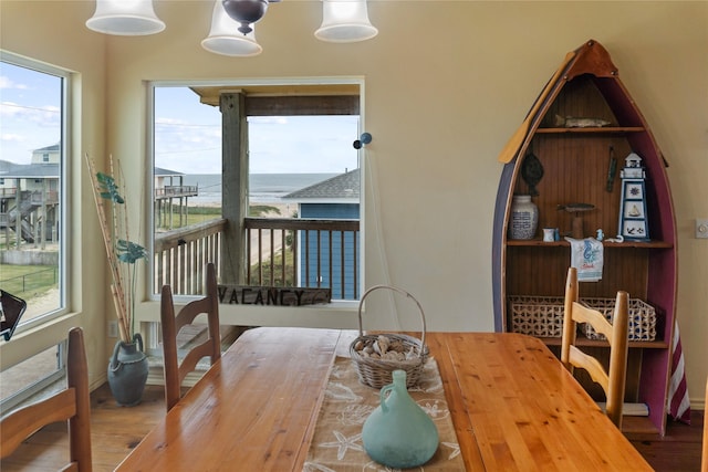 dining space with a water view and hardwood / wood-style flooring