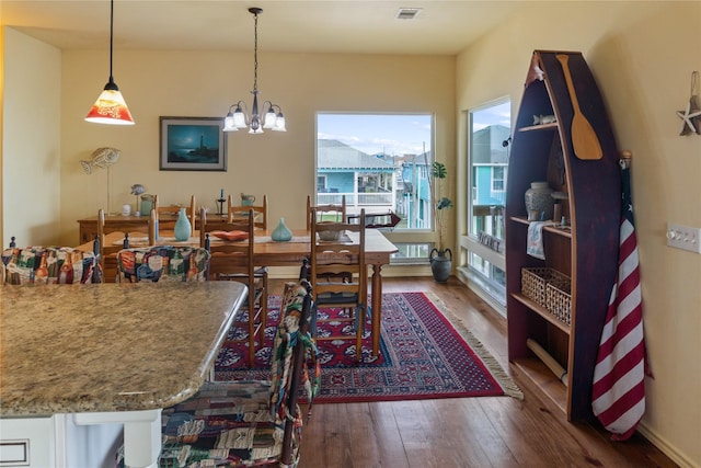 dining space featuring dark hardwood / wood-style floors and a chandelier