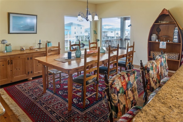 dining area with hardwood / wood-style floors and an inviting chandelier