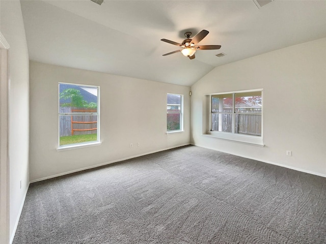 carpeted spare room with ceiling fan, plenty of natural light, and vaulted ceiling