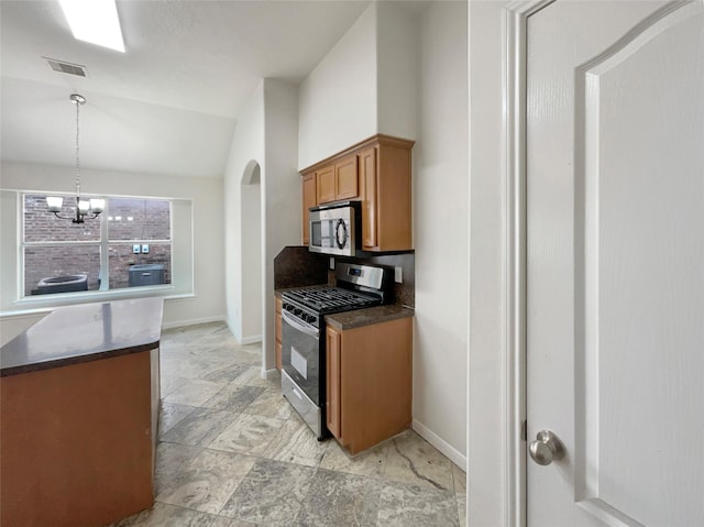 kitchen with pendant lighting, a notable chandelier, lofted ceiling, and appliances with stainless steel finishes