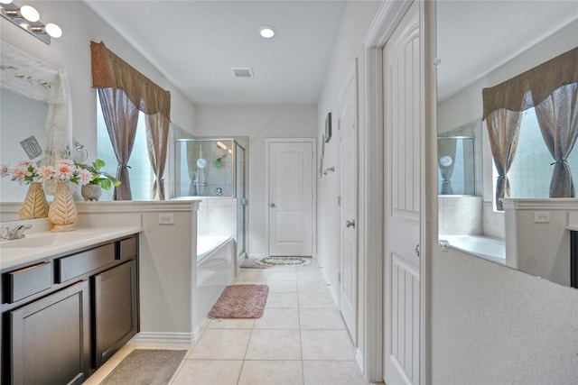 bathroom with tile patterned floors, vanity, separate shower and tub, and a wealth of natural light