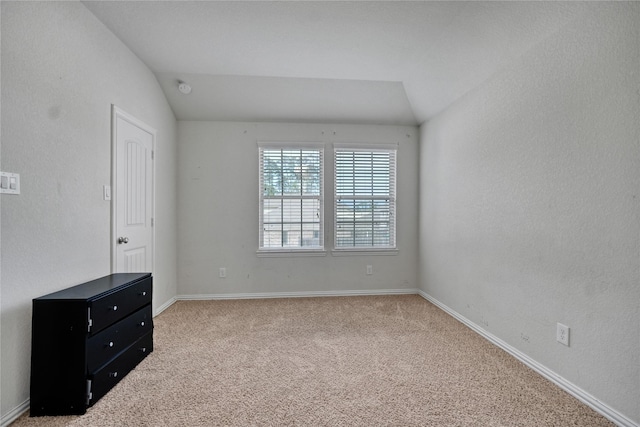 unfurnished room with carpet floors and lofted ceiling