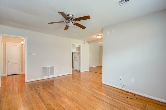 empty room with ceiling fan and light hardwood / wood-style flooring