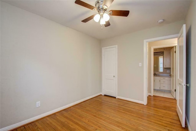 unfurnished bedroom featuring ceiling fan, a closet, and light hardwood / wood-style flooring