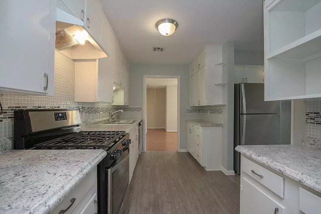 kitchen with backsplash, white cabinets, and appliances with stainless steel finishes