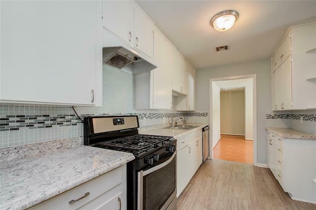 kitchen featuring backsplash, white cabinets, sink, light hardwood / wood-style flooring, and appliances with stainless steel finishes