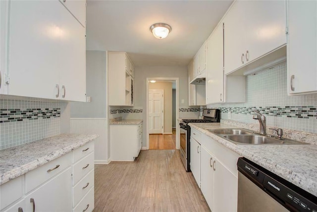 kitchen with sink, light hardwood / wood-style flooring, tasteful backsplash, white cabinetry, and stainless steel appliances