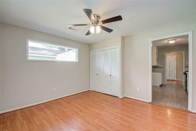 unfurnished bedroom featuring ceiling fan, a closet, and light hardwood / wood-style floors