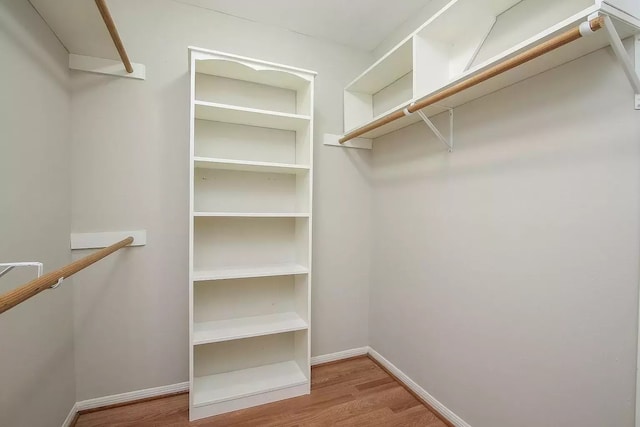 walk in closet with light hardwood / wood-style floors