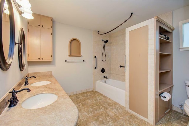 full bathroom featuring vanity, tiled shower / bath, and toilet