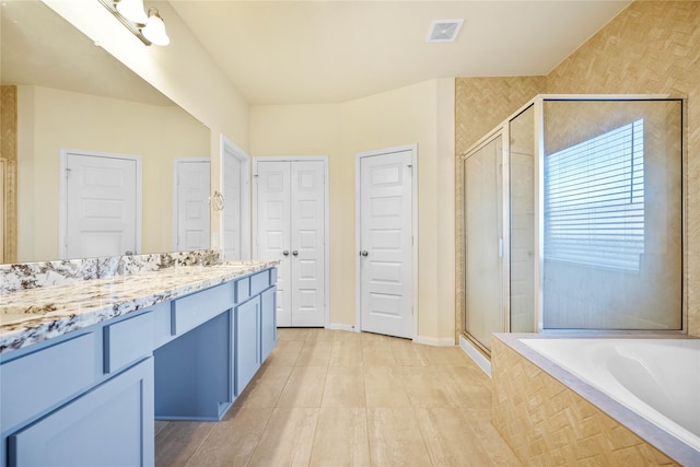 bathroom featuring vanity, tile patterned flooring, and plus walk in shower