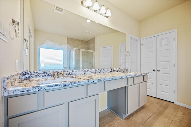 bathroom with tile patterned floors, a shower with door, and vanity