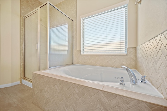 bathroom with shower with separate bathtub and tile patterned floors