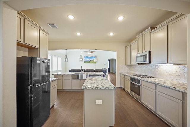 kitchen featuring kitchen peninsula, stainless steel appliances, wood-type flooring, a kitchen island, and hanging light fixtures