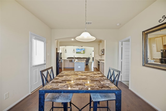 dining space featuring dark hardwood / wood-style flooring and sink