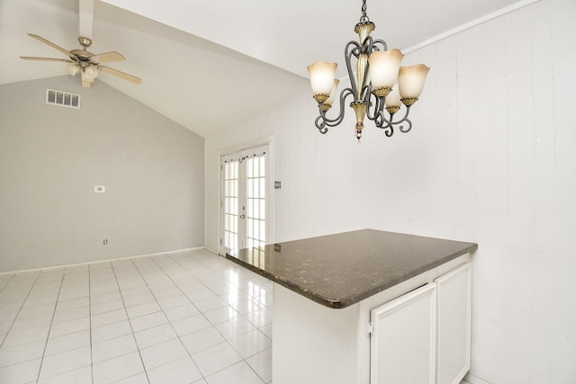 kitchen featuring lofted ceiling, french doors, light tile patterned floors, decorative light fixtures, and white cabinetry