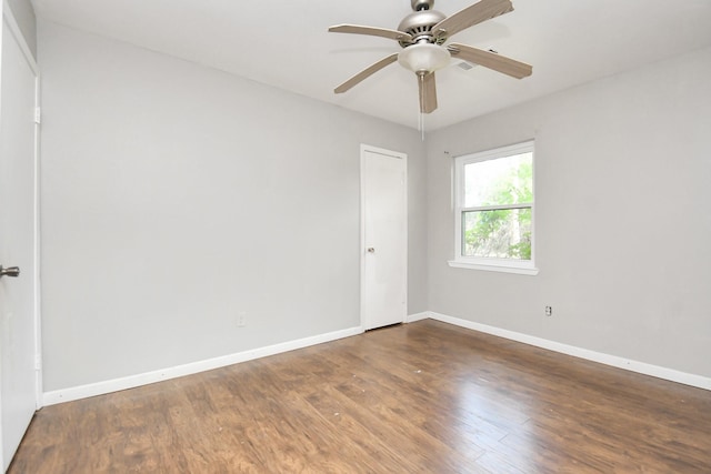 unfurnished room with ceiling fan and dark hardwood / wood-style flooring